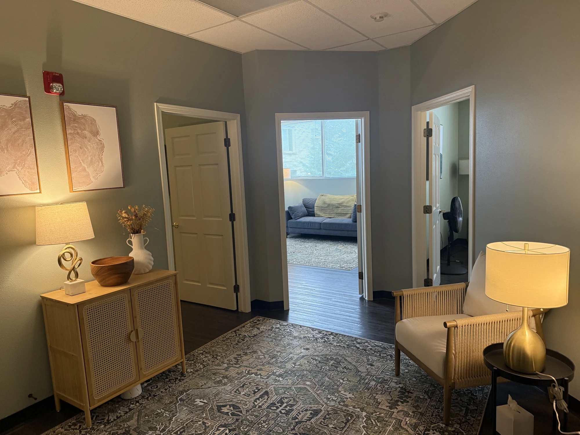 An internal Allis corridor with open doorways and a lit table lamp