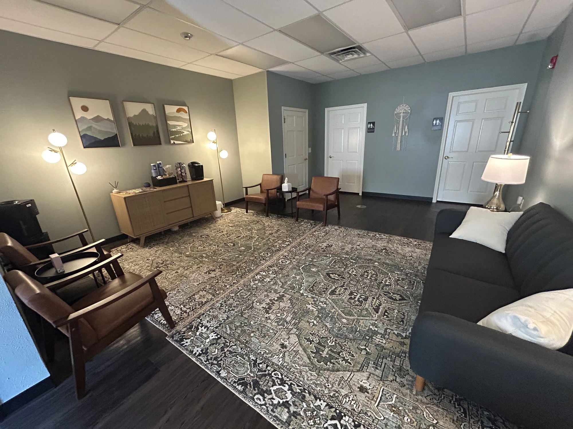 Wide view of the Allis shared seating area with sofas, chairs and warm lamps